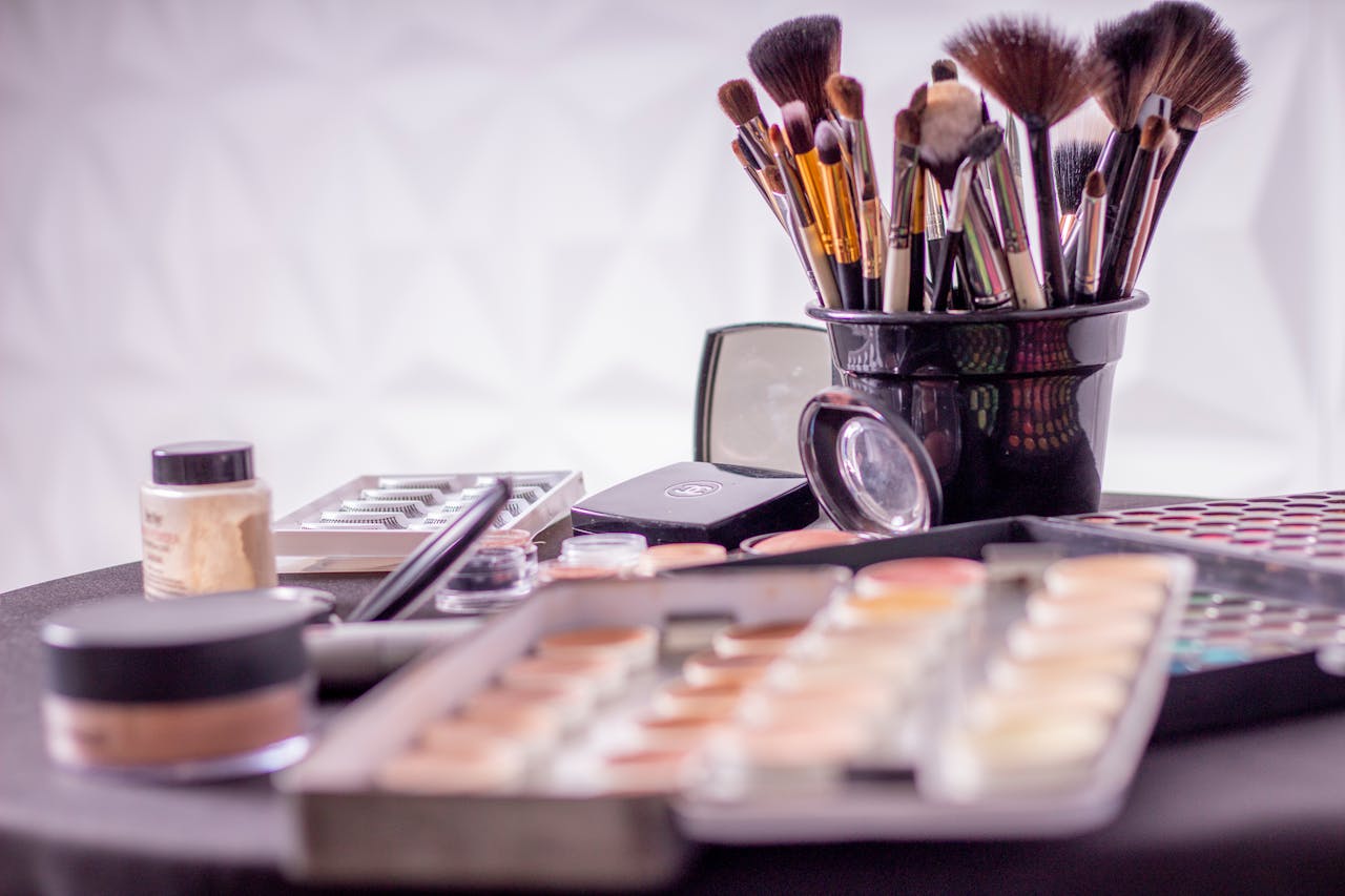 Close-up of a professional makeup brush set and cosmetics on a table for beauty use.